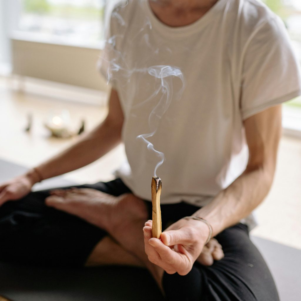 pexels photo 8436503 8436503 A person holding burning Palo Santo, focusing on relaxation and spiritual wellness.